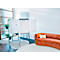 Flipchart und ein oranges Sofa in einem modernen, hellen Büro-Meetingbereich mit Pflanzen.