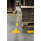 Yellow markings on a concrete floor, stacks of cardboard on pallets. Forklift and other goods in the background.