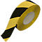 Close-up of a roll of black and yellow striped warning tape.
