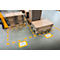 Pallets with cardboard boxes in a factory. Yellow markings on the floor and information signs.