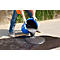 Person pours black asphalt from blue bucket onto street. Work clothes, gloves.
