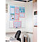 Whiteboard with posters and diagrams on a white wall. Office with chair, table, trash can.