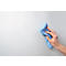 Bright hand wiping a gray surface with a blue microfiber cloth.