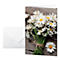 Greeting card with daisies next to a white envelope. On rustic wood.