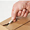 Hand opening a cardboard box. The hand tears tape to open the lid.