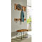 Houten wandgarderobe met hoed en jas. Daaronder nog haken met koptelefoon. Daaronder een bruine bank.