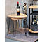 Deux tables d'appoint rondes avec des pieds noirs et une bouteille de vin. Une sculpture et un chariot de service en arrière-plan.