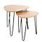 Deux tables ovales en bois clair avec des pieds en métal noirs et fins, gigognes.
