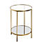 Table d'appoint ronde dorée avec deux étagères en verre. Sur fond clair.