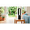 Zwarte torenventilator op houten tafel. Achtergrond: tuin, bank, planten.