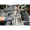 Een persoon schroeft met een sleutel op een metalen werktuigmachine.