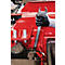 Close-up van een hand die een sleutel vasthoudt op een rood machineonderdeel. De handschoen is zwart, de achtergrond is wazig.