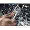 Vies hand die een sleutel vasthoudt op een automotor. Details: metaal, motor, gereedschap.