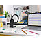 Black headset on a charging station, a laptop and other office accessories on a desk.