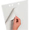 Eine Hand blättert eine Ecke eines karierten Flipchart-Papiers mit Lochung um.