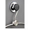 Chrome towel holder, mounted on grey wall. Black knob with lettering. Below the bracket a towel ring.