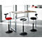 Three ergonomic stools in front of a desk. One is red, the others are black.