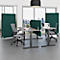 Büro-Szene mit mehreren Schreibtischen und grünen Trennwänden. Graue Bürostühle stehen an den Tischen. Im Hintergrund ist eine Stadtlandschaft zu sehen.