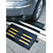 Black car ramp in front of car tire; yellow stripes.