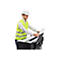 Ein Mann in Warnweste und Helm legt ein Blatt Papier in einen Drucker.