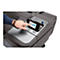 Ein Mann bedient mit seinem Finger einen Touchscreen an einem Drucker. Das Gerät ist schwarz und grau.