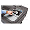 Nahaufnahme eines Mannes, der mit dem Finger auf den Touchscreen eines grauen HP DesignJet Z9 PostScript Druckers tippt. Auf dem Bildschirm sind Druckaufträge und Optionen sichtbar. Der Mann trägt ein blaues Hemd und eine Uhr mit braunem Lederarmband.
