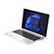 Ein silberner Laptop mit offenem Bildschirm. Auf dem Display ein Windows-Desktop mit Apps, darunter ein blauer Hintergrund.