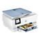 Ein weißer HP Envy Inspire Drucker. Mit blauem Deckel, Bedienfeld und Papierschublade. Ein Blatt mit Fotos von Gärten wird ausgedruckt.
