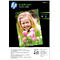 A smiling girl holding pink tulips, on a pack of HP photo paper.