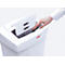 A person places paper into a shredder. The paper has lines and rectangular holes. The shredder is white with the inscription "HSM".