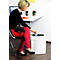 A woman in red pants places a card into a shredder. On the desk is a glass and a flower.