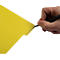 Een hand schrijft met een zwarte pen op een gele pagina. Op de pagina staat "PLANNING".