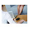 Femme avec un ordinateur portable sur une table, jambes sur un canapÃ© en arriÃ¨re-plan. Sur la table : microphone.