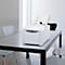 Witte printer met open lade staat op een tafel. Op de achtergrond stoelen, raam.