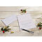 Kerstkaart met handgeschreven boodschap, pen, envelop en kerstversiering op een houten ondergrond.