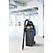 Aspirateur industriel noir sur conteneur à déchets gris, devant un bureau lumineux. L'aspirateur porte l'inscription Mammut.