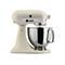 Beigefarbene KitchenAid Artisan Küchenmaschine mit silberner Edelstahlschüssel vor weißem Hintergrund.