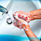 Hands being washed with soap under running water.