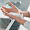 Hands holding a cleaning wipe. One hand is holding the wipe up and the other is wiping the palm.