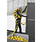 A young woman holds a black and yellow striped barrier. She stands in front of a building with a gray background and a box with the barrier.
