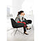 A woman in a gray blazer sits in a black chair, thoughtfully looking out the window.