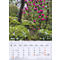 Calendrier avec les dates de mars 2027, avec des fleurs rouges en fleurs et des plantes vertes en arrière-plan.