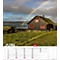 Un arc-en-ciel enjambe une maison avec un toit en herbe et des encadrements de fenêtres rouges. Au premier plan, une prairie, à l'arrière-plan, la mer et les montagnes.