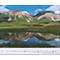 Les montagnes se reflètent dans l'eau, vallée verte et ciel bleu.