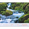 Eau courante d'une cascade entre des rochers couverts de mousse, un tableau de calendrier au premier plan.
