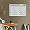 Calendrier mural pour 2027 sur un mur. Tasse, horloge et vase sur un bureau.
