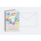 Carte d'anniversaire avec des ballons colorés et l'inscription "Joyeux anniversaire". À côté, une enveloppe blanche.