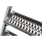 Close-up van een ladder met metalen treden. De treden hebben een patroon van langwerpige gaten. Schroeven bevestigen de treden aan de steunen.