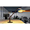 A stylish desk lamp with an arm, standing on a table. A hand is approaching the light. In the background an office.