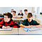 Schüler in einem Klassenzimmer arbeiten konzentriert an weißen Tafeln auf ihren Schreibtischen.